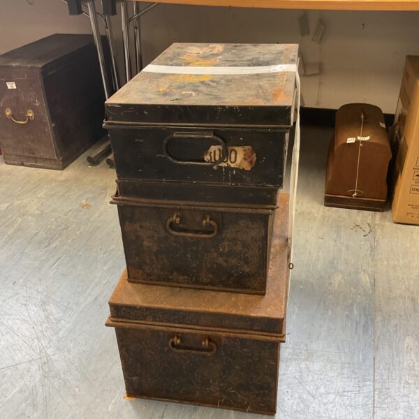 Stacked vintage metal deed boxes for antique storage.