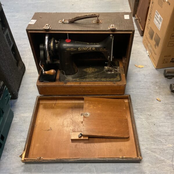 Vintage Singer sewing machine in wooden case, antique collectible.