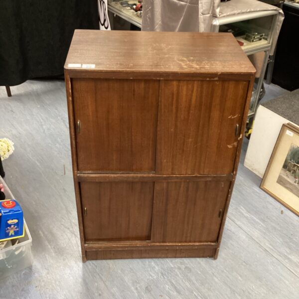 Dark wood Herbert Gibbs vinyl record cabinet with sliding doors.