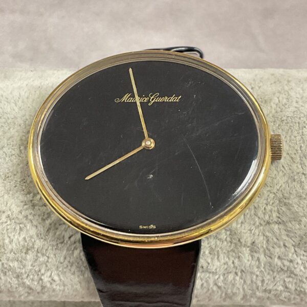 Vintage Maurice Guerdat wristwatch with black dial and leather strap.