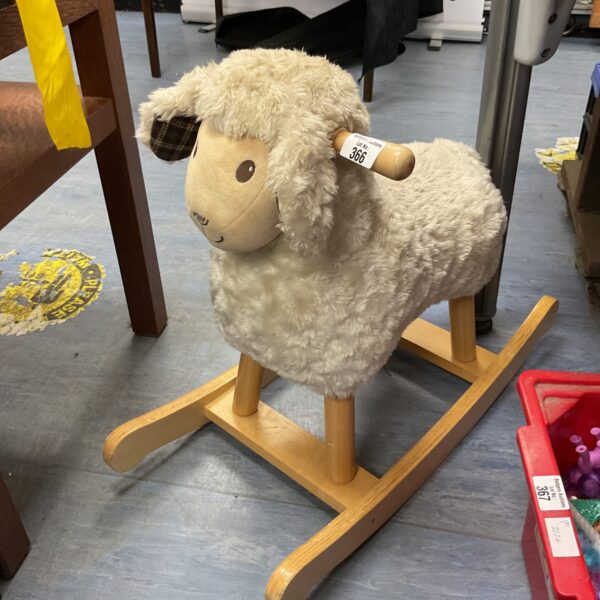 Vintage wooden rocking sheep toy for nursery decor.