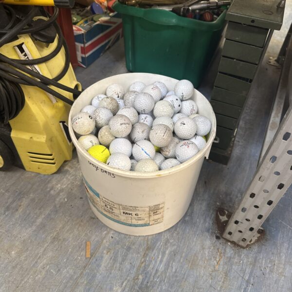 Bucket of mixed used golf balls for practice and play.