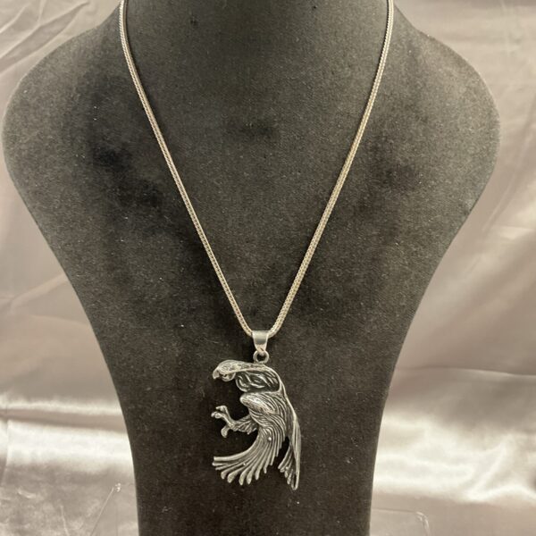 Detailed silver eagle pendant necklace on a silver chain.