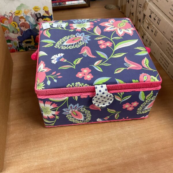 Vibrant floral sewing box with pink trim and pom-poms.