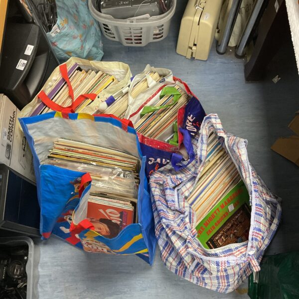 Large bags filled with a diverse vintage vinyl record collection.