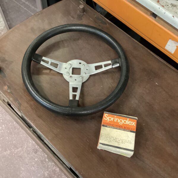 Vintage MGB steering wheel with boss adapter for classic car restoration.