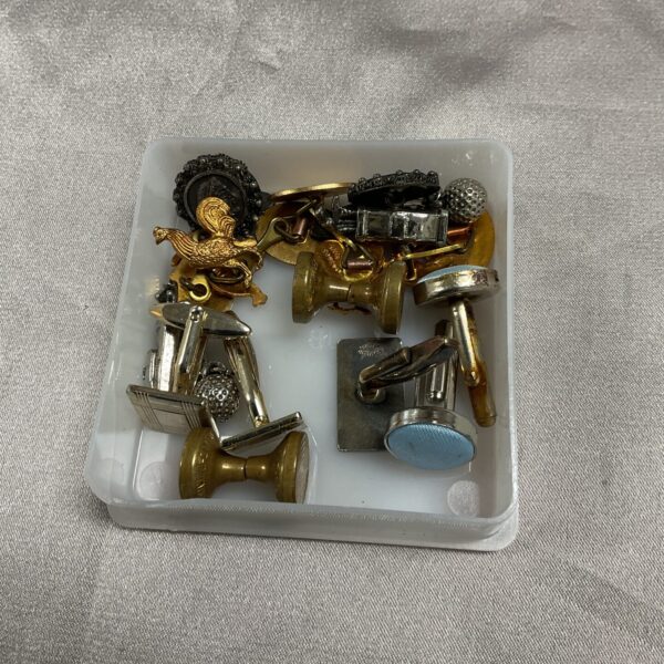 Vintage cufflinks assortment displayed in a tub, collectible men's accessories.