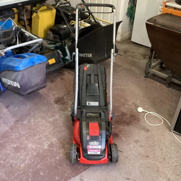 Ozito X Power cordless lawnmower in a garden setting.