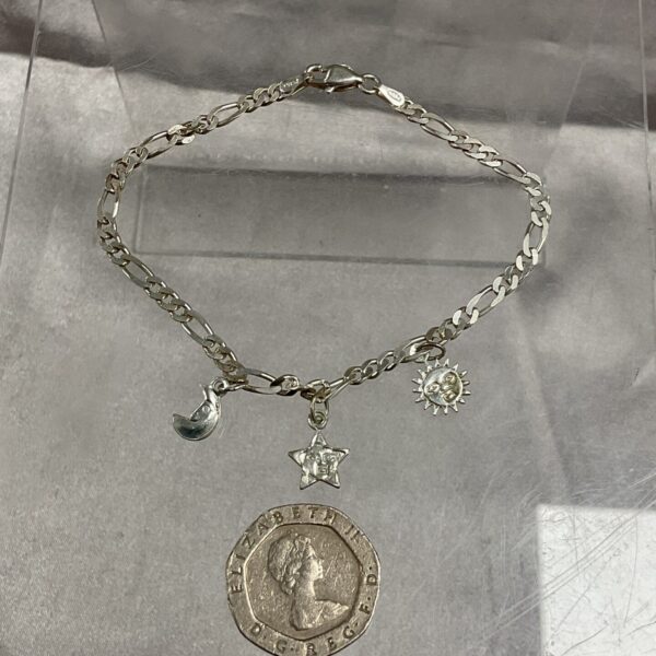 Silver charm bracelet with sun, moon, and star pendants.