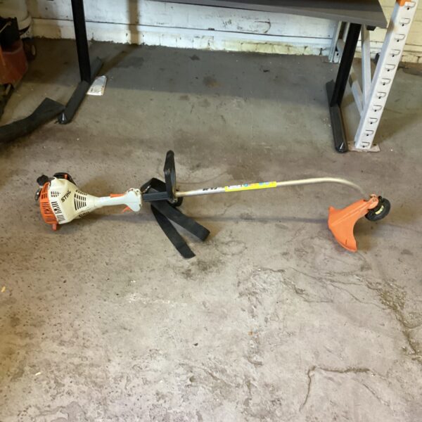 Used Stihl FS38 petrol strimmer in garden setting.