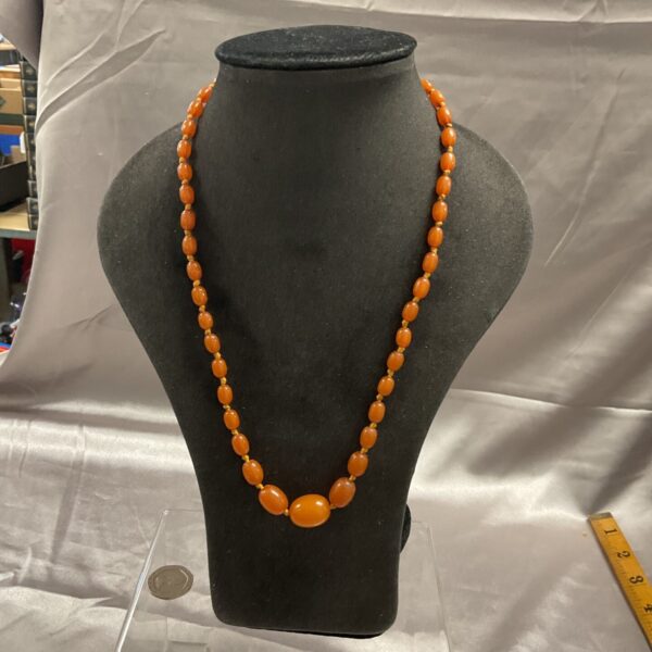 Close-up of a vintage amber bead necklace with warm honey tones.