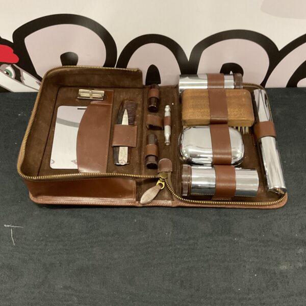 Vintage brown leather travel grooming set with grooming tools.