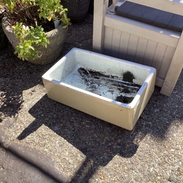 Vintage Belfast sink with chipped enamel, ideal for restoration.