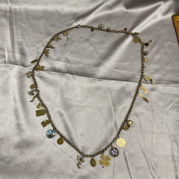 Close-up of vintage charm necklace with enamel and skull charms.