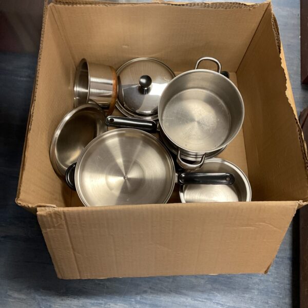 Stainless steel pots and pans in a cardboard box.