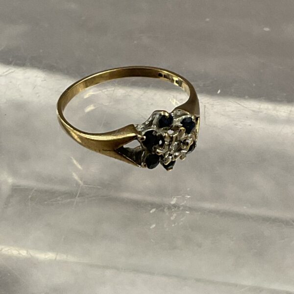 Elegant 9 carat gold ring with sapphire and diamond detailing.