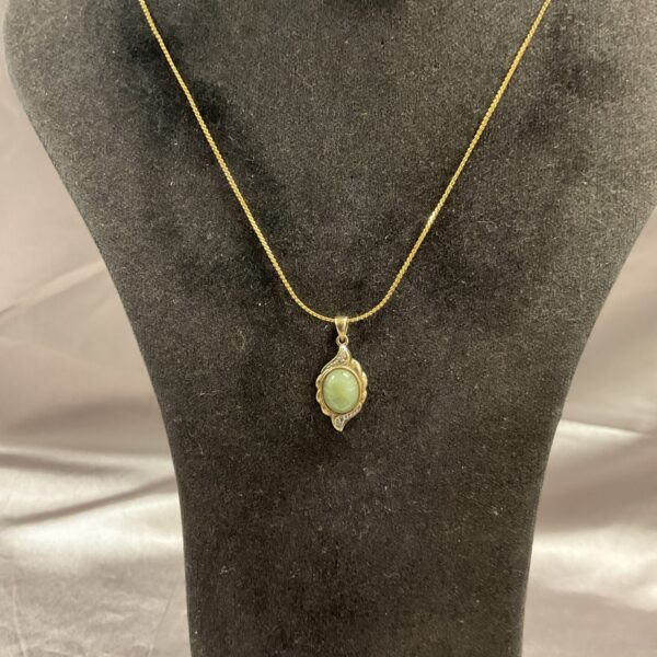 Vintage green jade pendant on a delicate gold chain necklace.