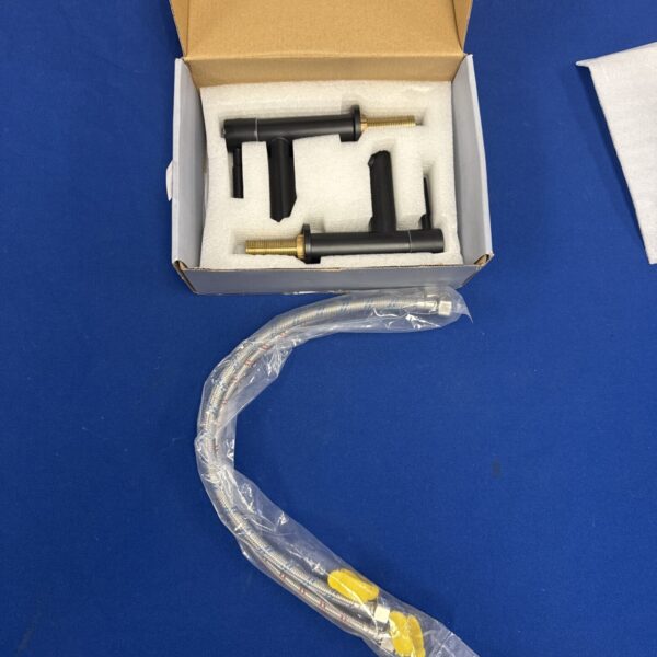 Pair of new matt black basin taps in original packaging.