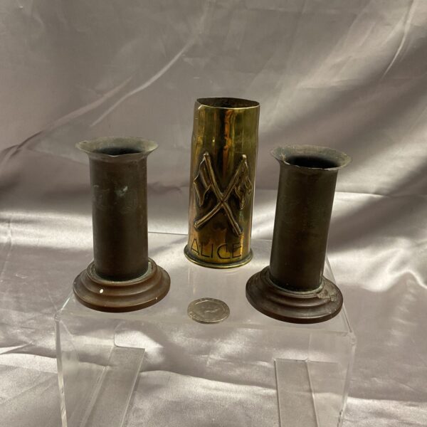 Three vintage brass trench art shell cases displayed together.