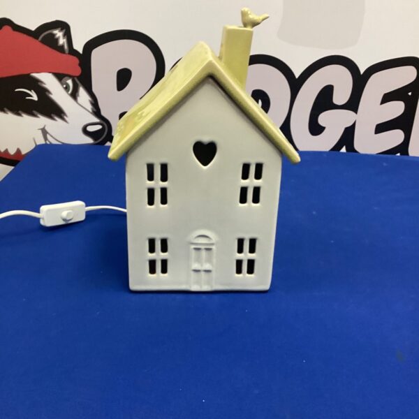 White ceramic house shaped table lamp for home decor.