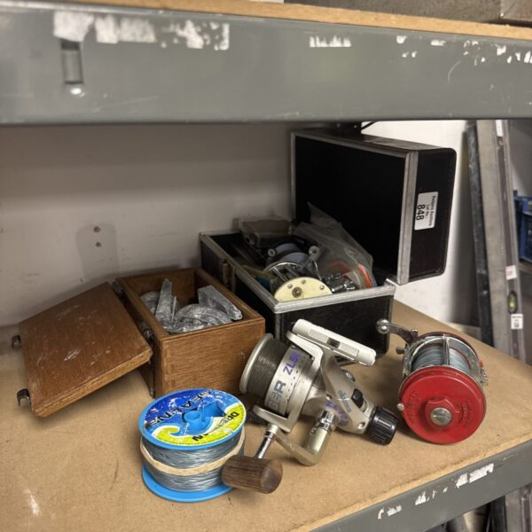 Vintage fishing reel and tackle lot with weights and cord.