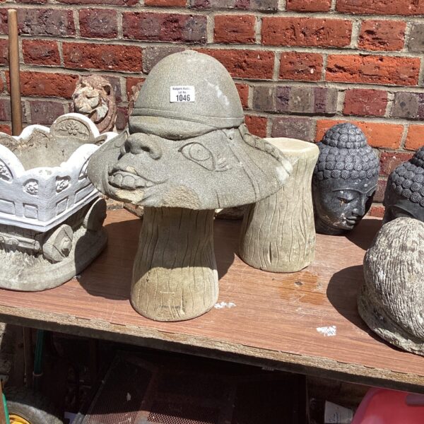 Stone effect garden mushroom statue on a stand.