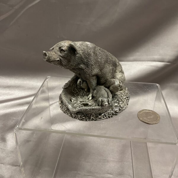 Detailed silver Country Artists pig figurine on display.