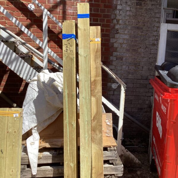 Three bundles of rough-sawn timber outdoors.