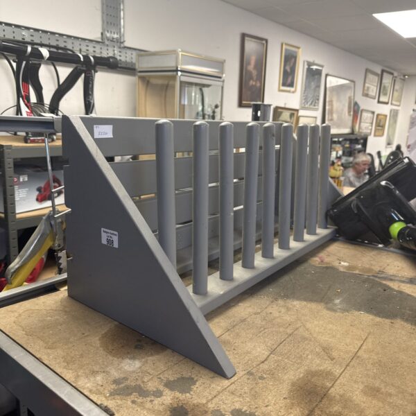Wooden wellington boot rack for storing boots in a hallway.