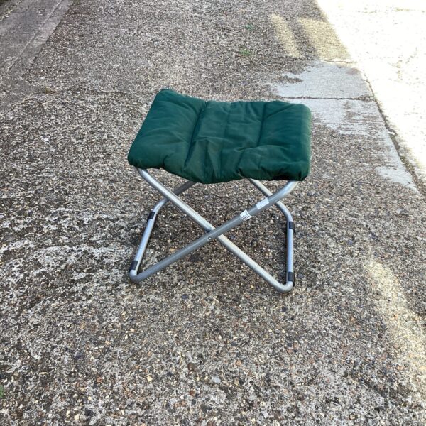 Green folding fishing chair, portable outdoor seating.