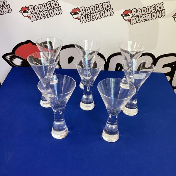 Set of eight elegant cocktail glasses for serving drinks.
