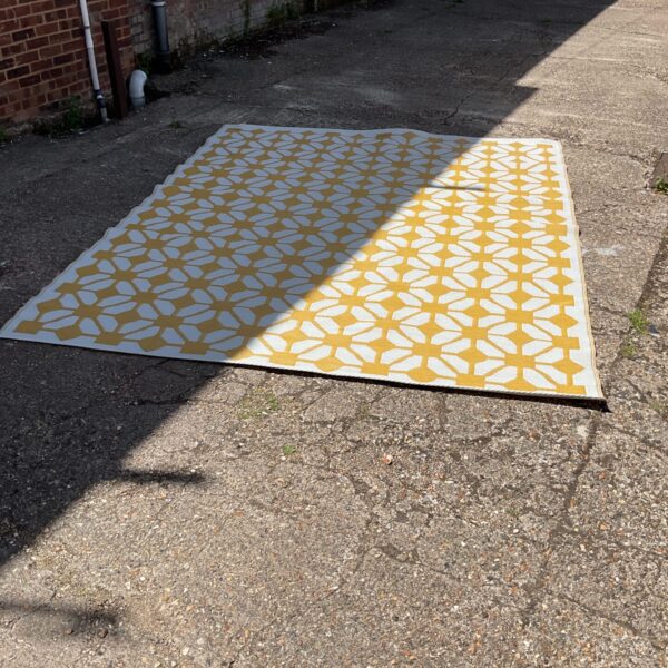 Large yellow and white geometric outdoor rug for garden or patio.
