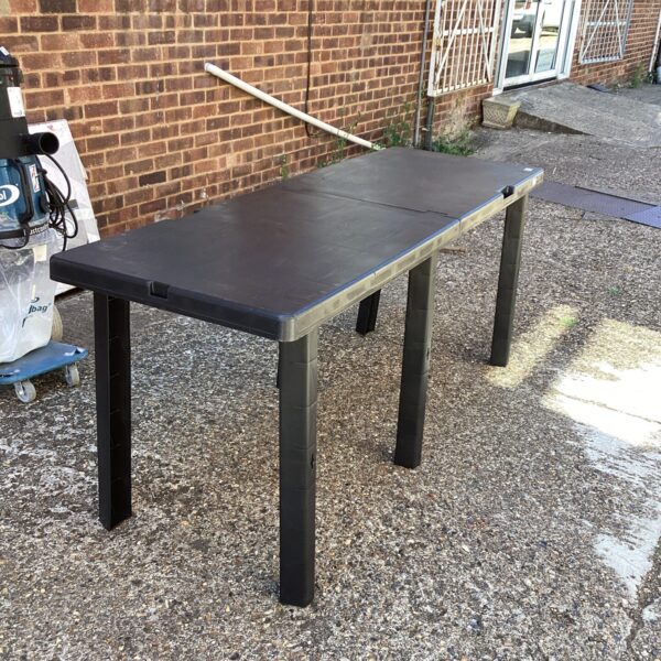 Durable folding plastic table set up outdoors for use.