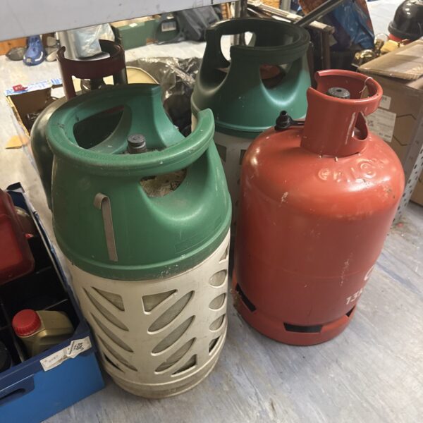 Lot of four used patio gas bottles for outdoor heating.
