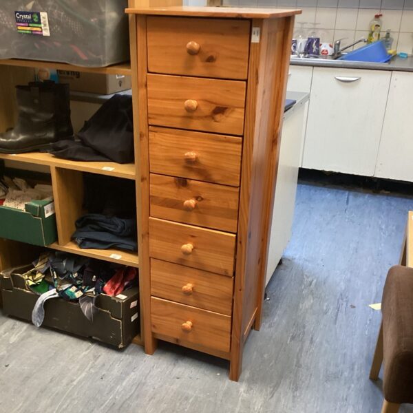 Vintage pine chest of drawers with seven drawers for bedroom storage.
