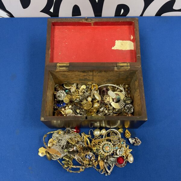 Vintage costume jewellery lot displayed in a wooden box.