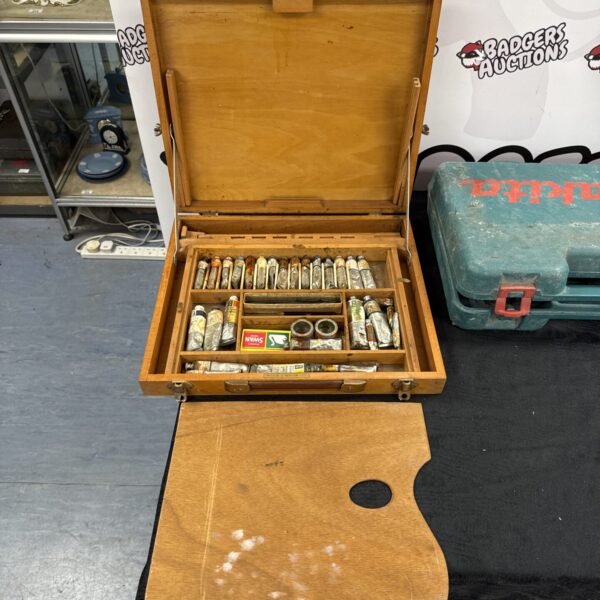 Vintage Windsor & Newton artist paint box with art supplies inside.
