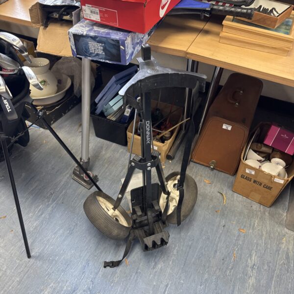 Vintage Donnay folding golf trolley in a cluttered space.