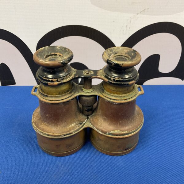 Antique brass binoculars with leather detailing, side view.