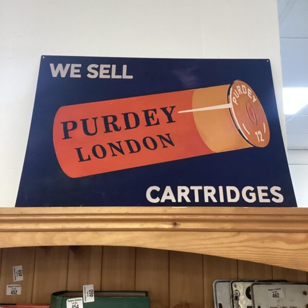 Vintage Purdey shotgun sign with cartridge illustration.