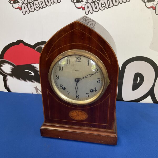 Antique Ansonia Lancet mantle clock with a carved wooden case.