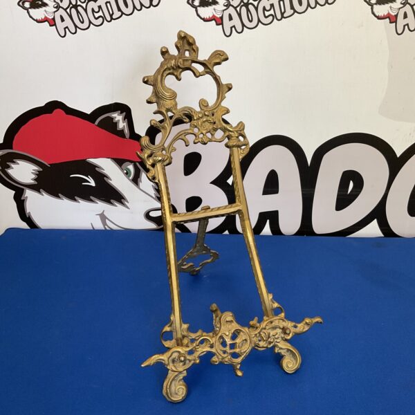 Ornate antique brass picture easel for displaying photos.