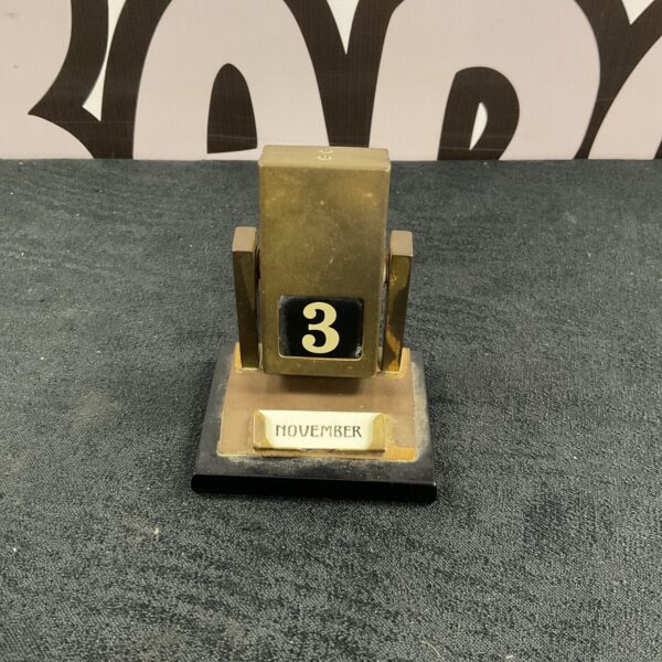 Vintage brass desk calendar displaying the date.