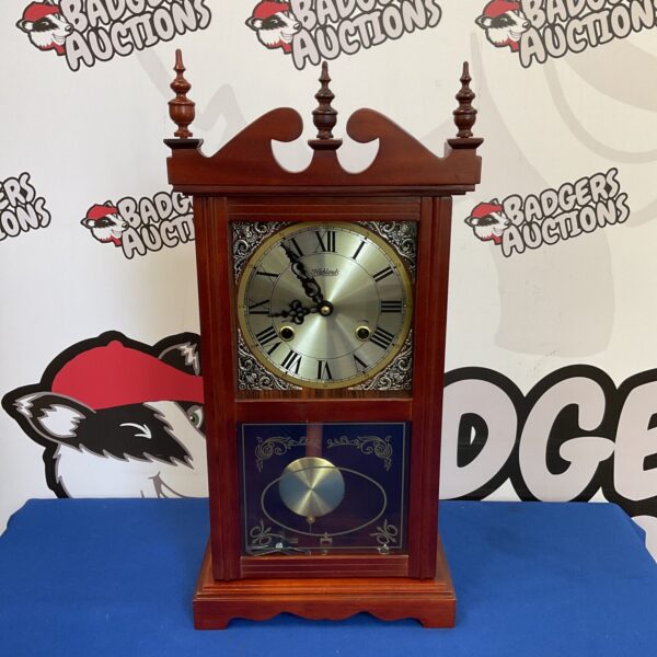 Vintage Highland mechanical clock with pendulum and key.