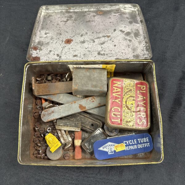 Vintage Players tin filled with bicycle repair tools.