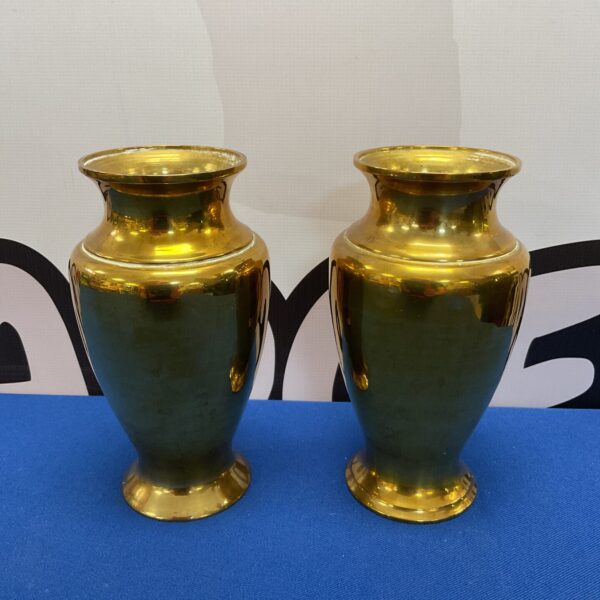 Pair of heavy brass urn vases on a dark surface.