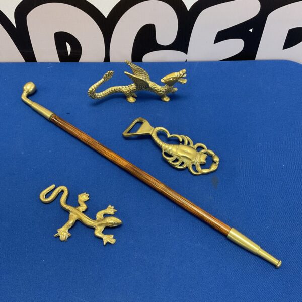 Detailed vintage brass bottle opener with dragon, lizard, and scorpion.