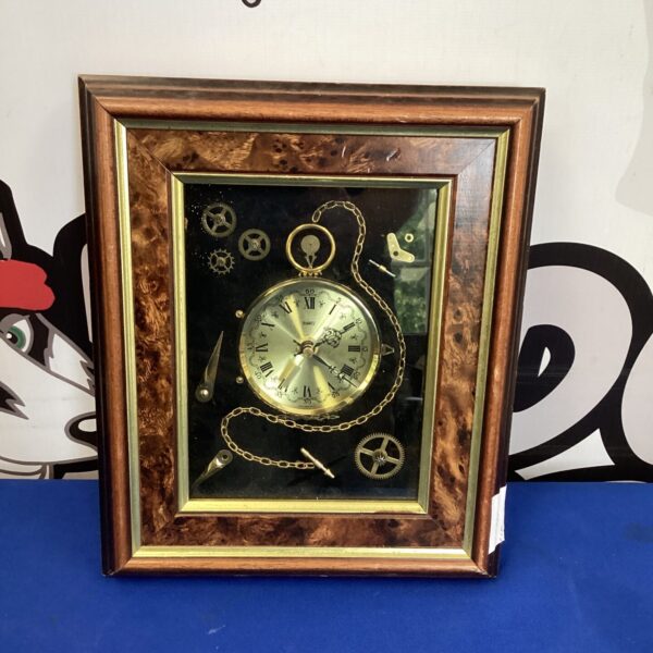 Vintage Ken Broadbent collage quartz clock on a wall.