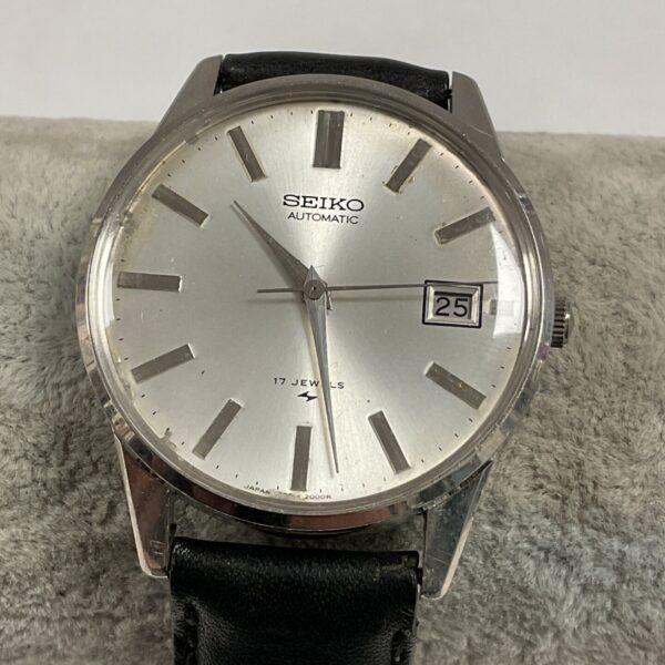 Vintage Seiko automatic watch with silver dial and black strap.