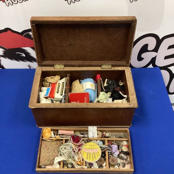 Open vintage sewing box filled with colourful threads and buttons.